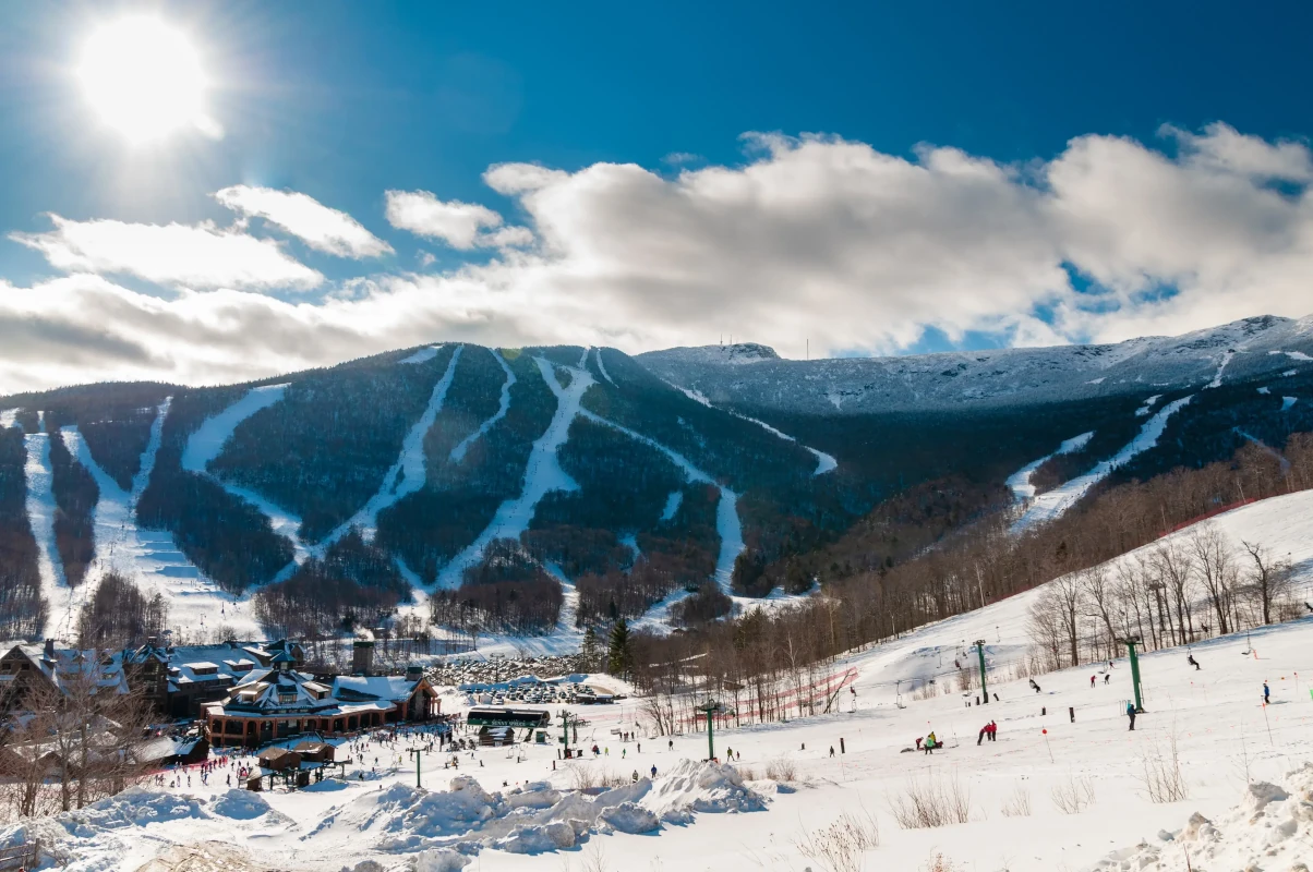 Spruce Peak Lodge in the winter with Mt. Mansfield in the background, Stowe, Vermont, USA