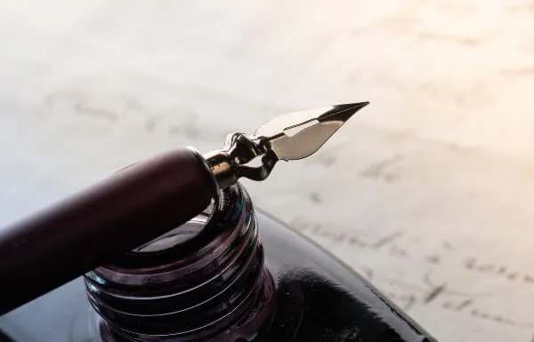 Fountain pen on an antique inkwell.