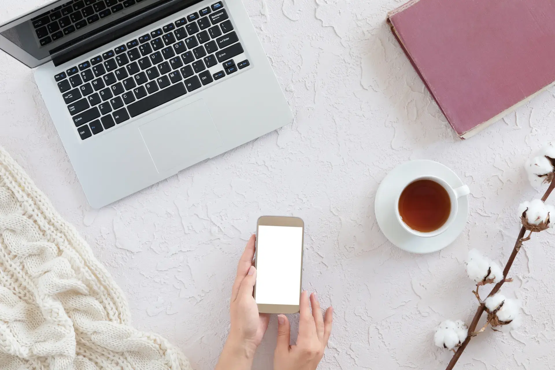 top view of old book, smart phone, cup of tea, cotton branch on concrete background, flat lay