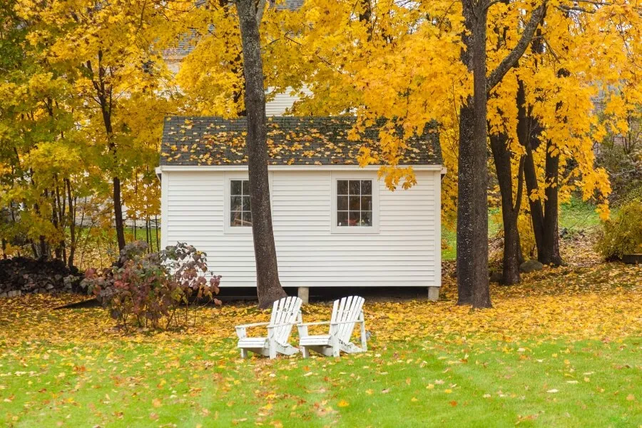USA, Maine, Wiscasset. Shed and Adirondack chairs during autumn.