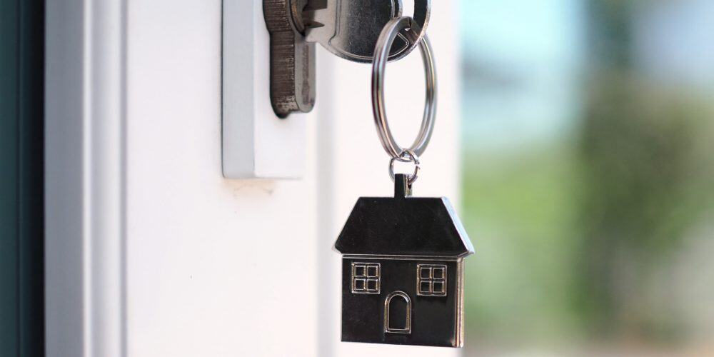Close up of sold sign in front of a blue house