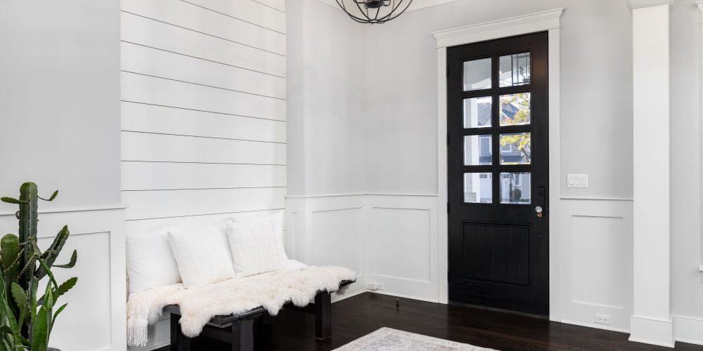 Navy blue front door in a covered portico with white and light gray trim