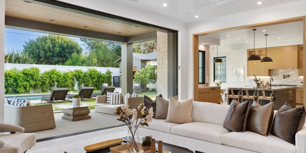 Modern living room with open sliding doors to patio and garden.