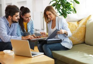 realtor sitting with couple on couch talking