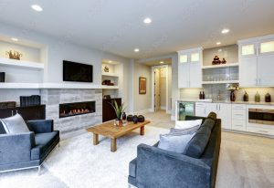Beautiful, well lit living room with grey sofa and chair and fire place