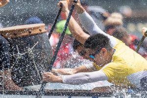 close up view of crew racer in boat with water splashing