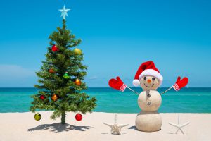 Christmas tree and sand snowman on beach