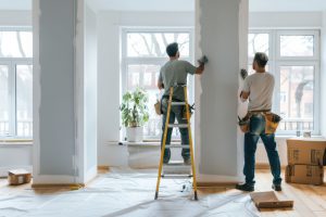 Two male contractors painting interior of home