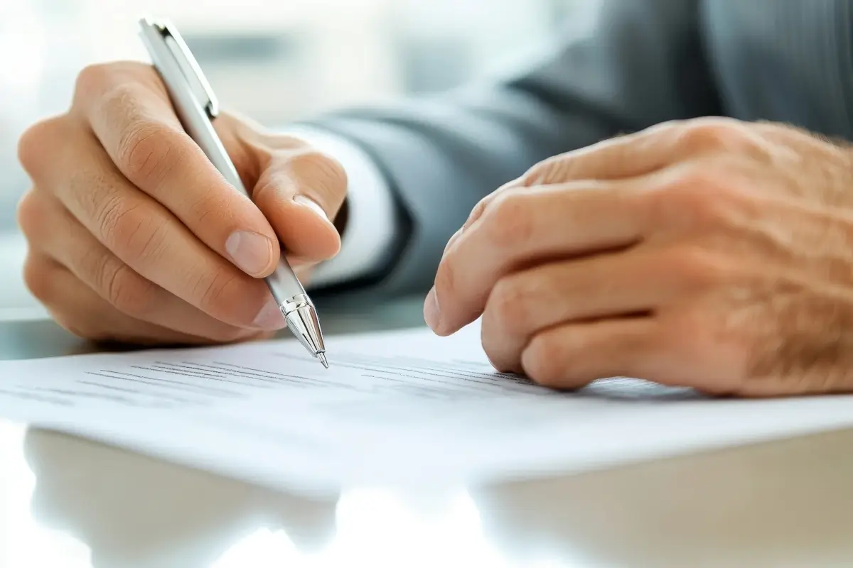 Close-up of hands of a realtor explaining a lease contract to a client on the table