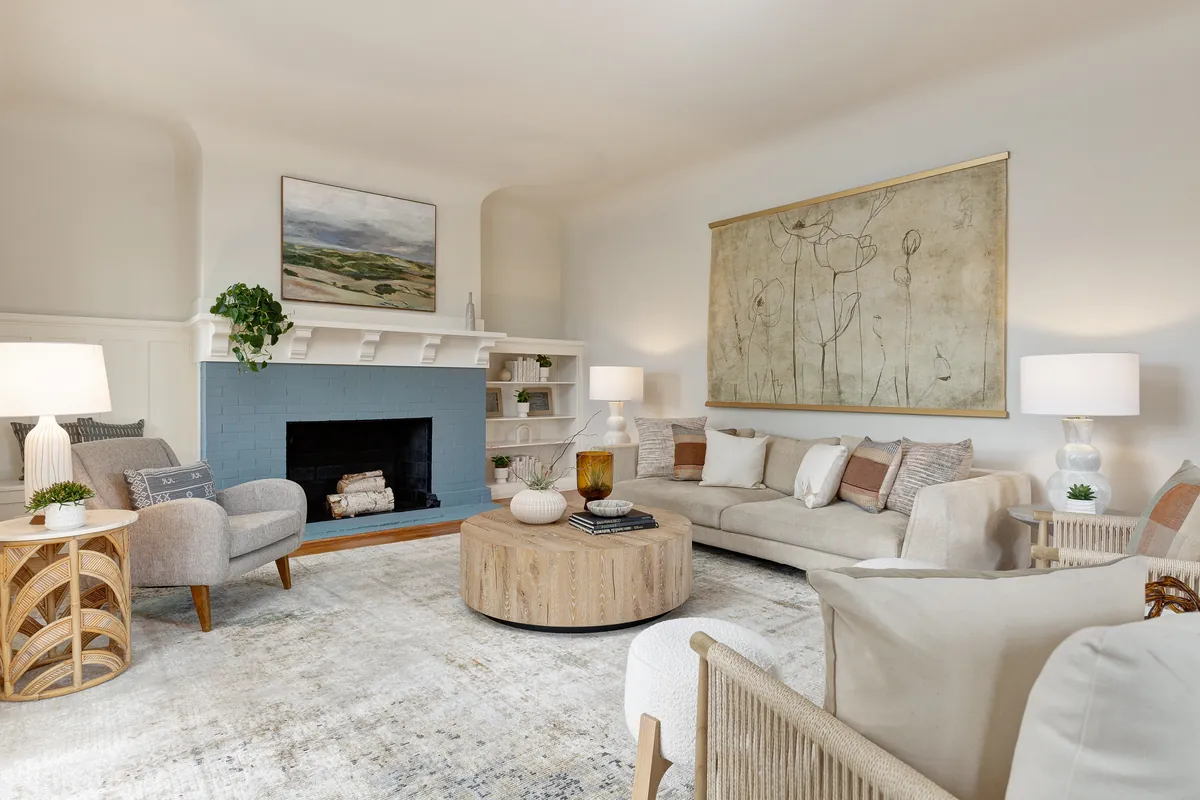Bright living room with a blue-painted fireplace and neutral furniture