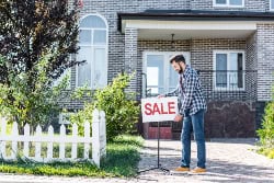 Realtor displaying a for sale sign