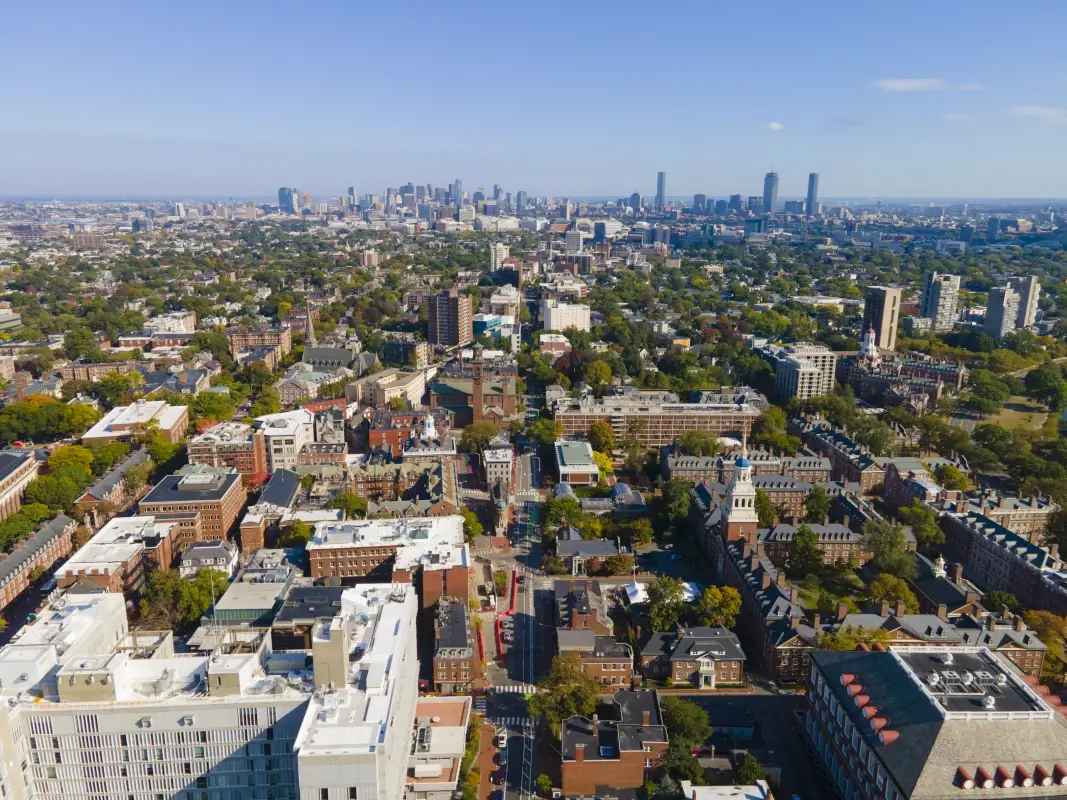 Aerial view of historic city center of Cambridge on Mt Auburn Street with Boston modern city skyline at the background, Cambridge, Massachusetts MA, USA.