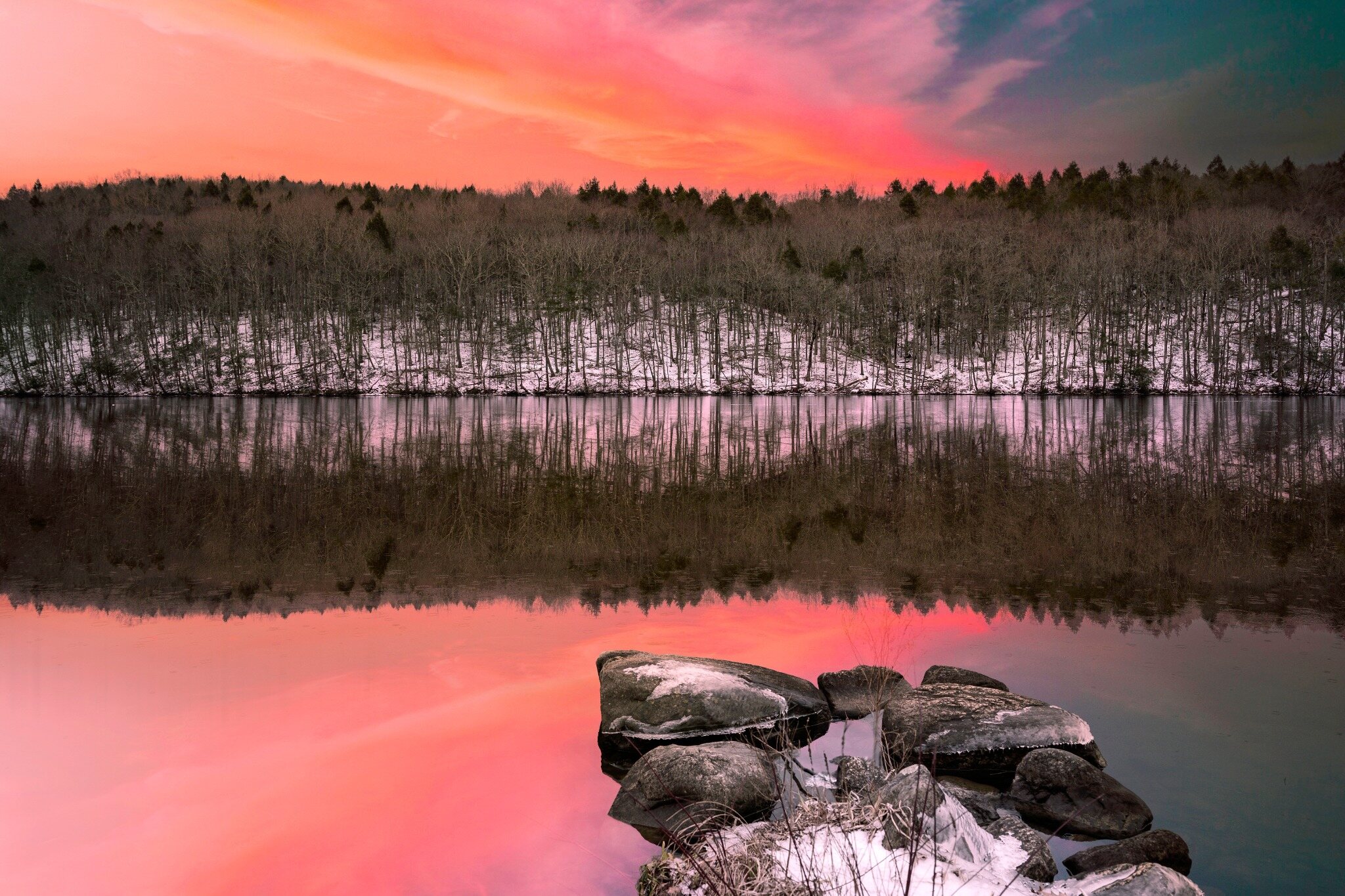 Winter sunset over a wooded reservoir in Monroe, CT