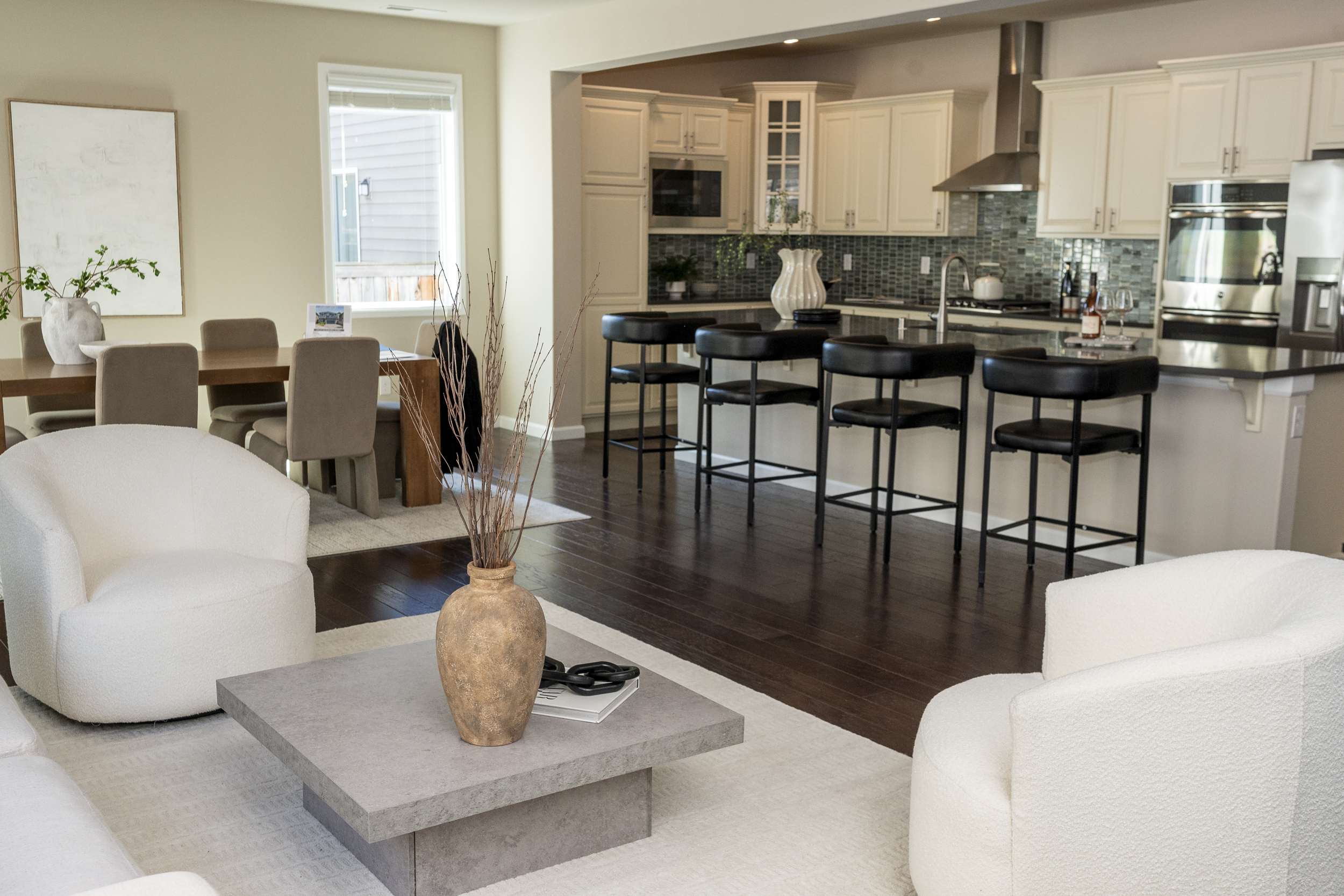 An open living and dining area connects to a white kitchen.