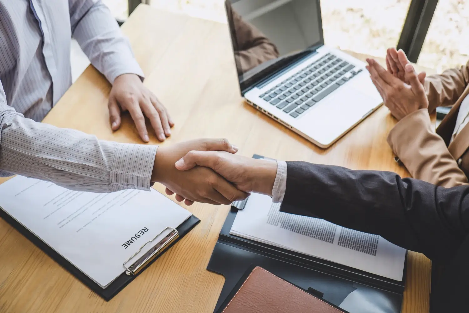 Greeting new colleagues, Handshake while job interviewing, male candidate shaking hands with Interviewer or employer after a job interview, employment and recruitment concept