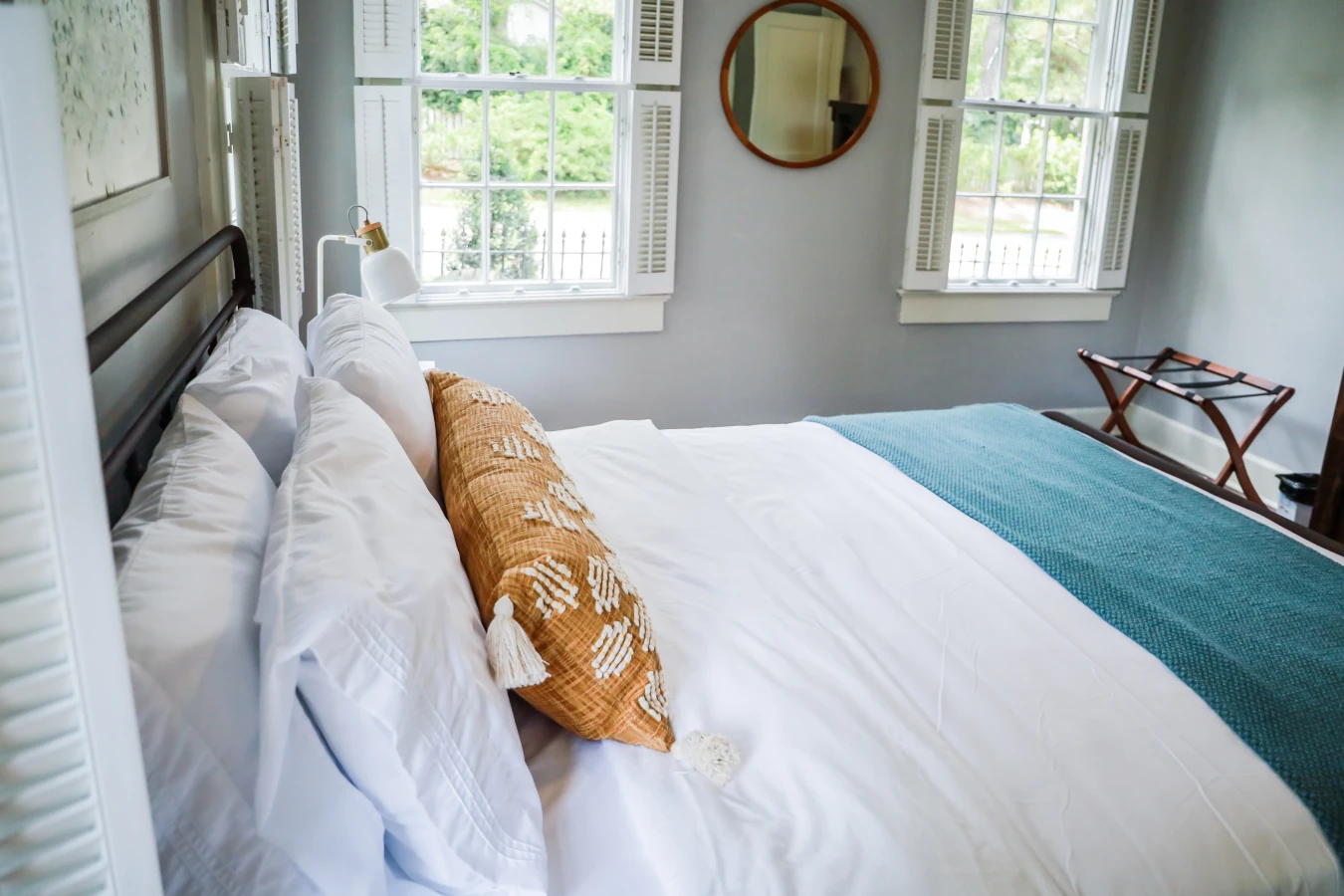 A guest bedroom with a queen sized bed and nightstand at a short term rental small cottage style house