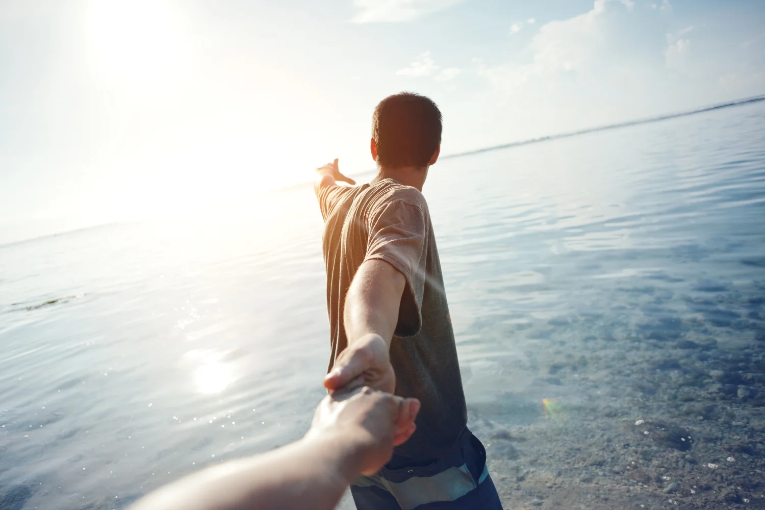 Brave man guiding traveling woman through the water