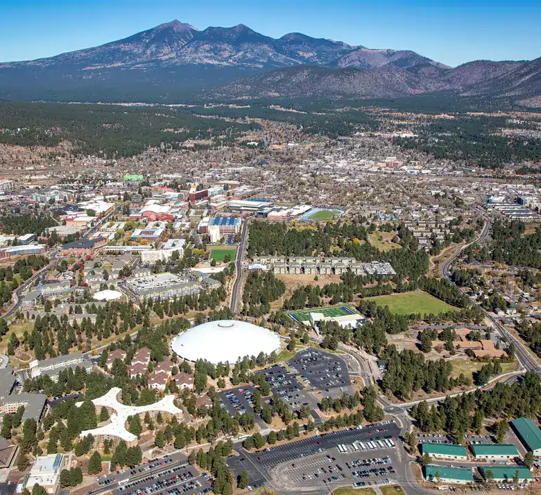 Aerial view of Flagstaff with the forested slopes of the San Francisco Peaks beyond