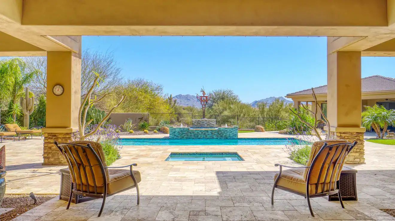 Covered back patio overlooking a pool
