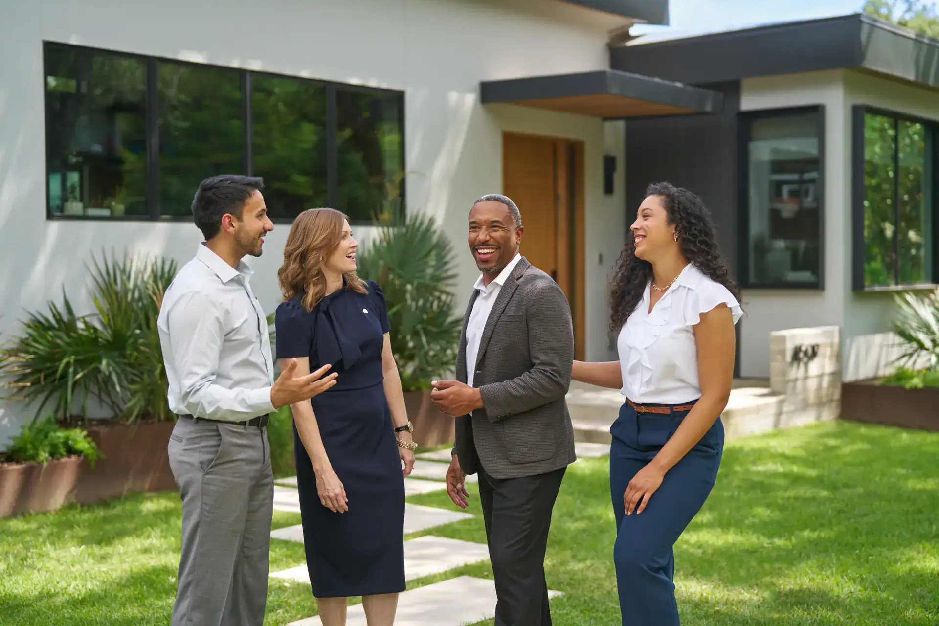 Century 21 agents laughing together on a front lawn