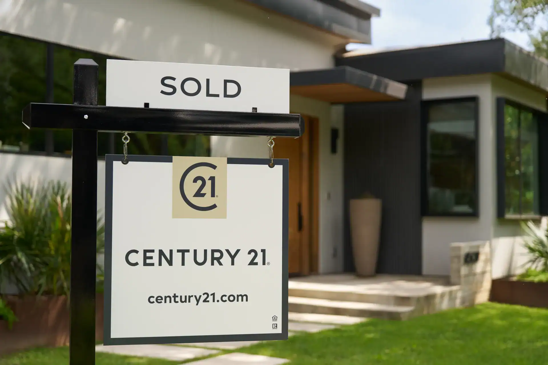 Century 21 SOLD sign in front of a modern home