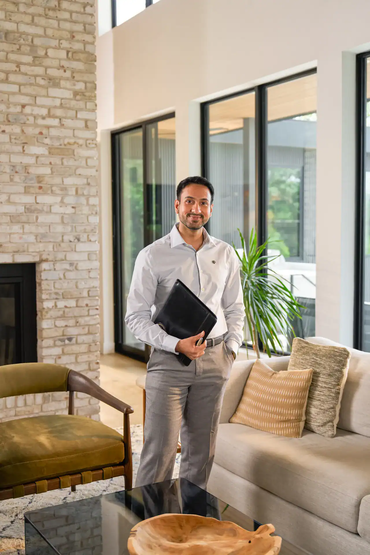 Century 21 agent holding a folder in a living room