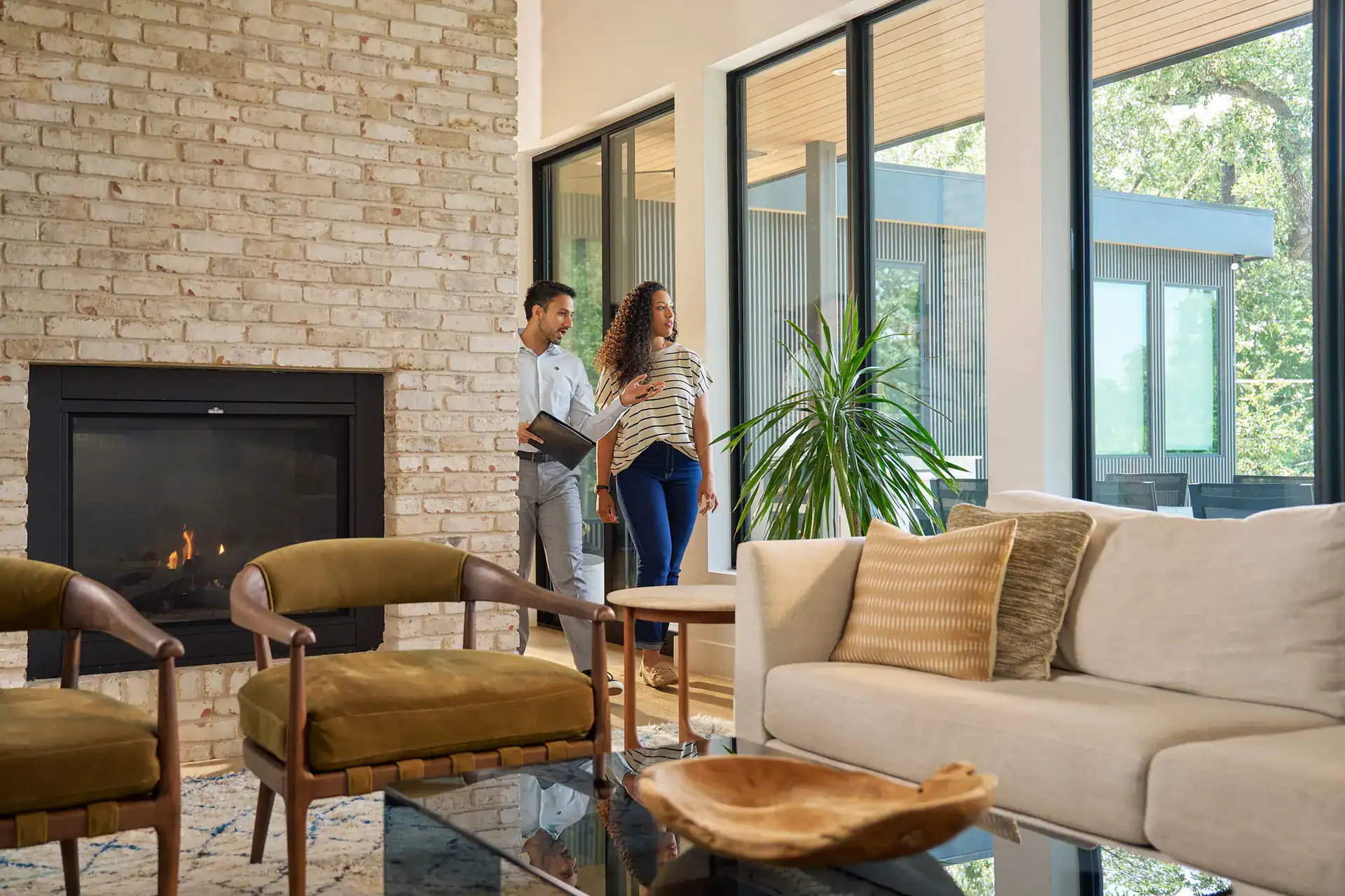 Agent showing a client a living room with a fireplace