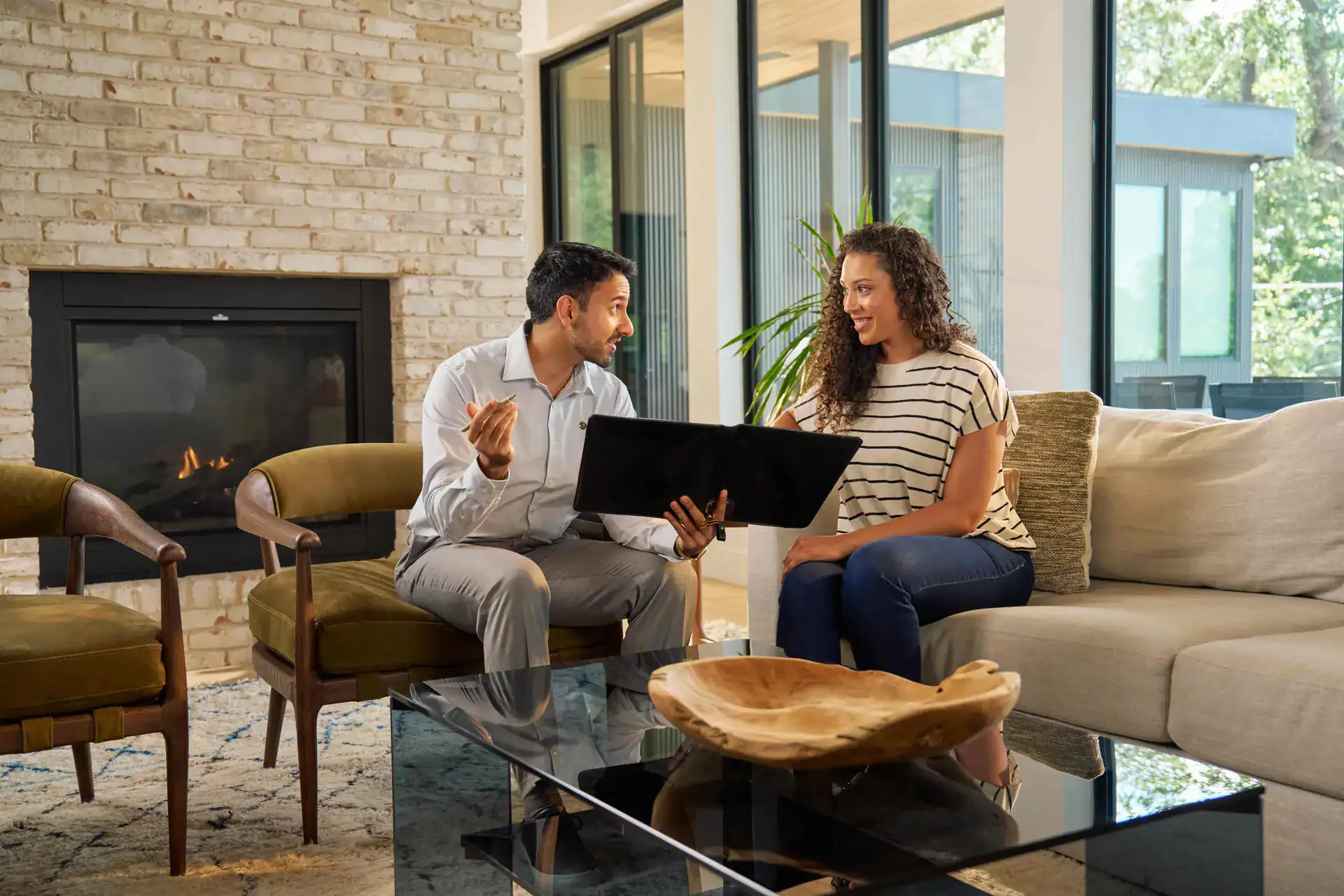 Agent showing a client a tablet in a living room