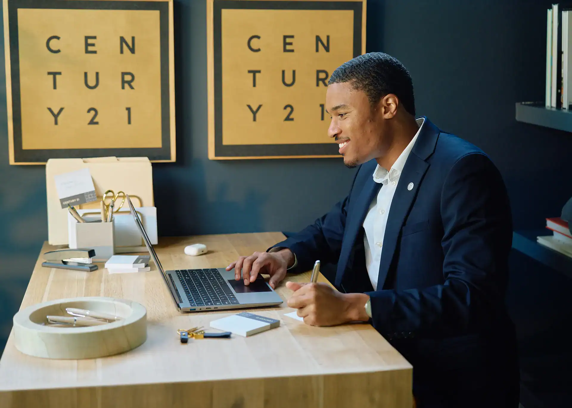 Century 21 agent working at a laptop in the office