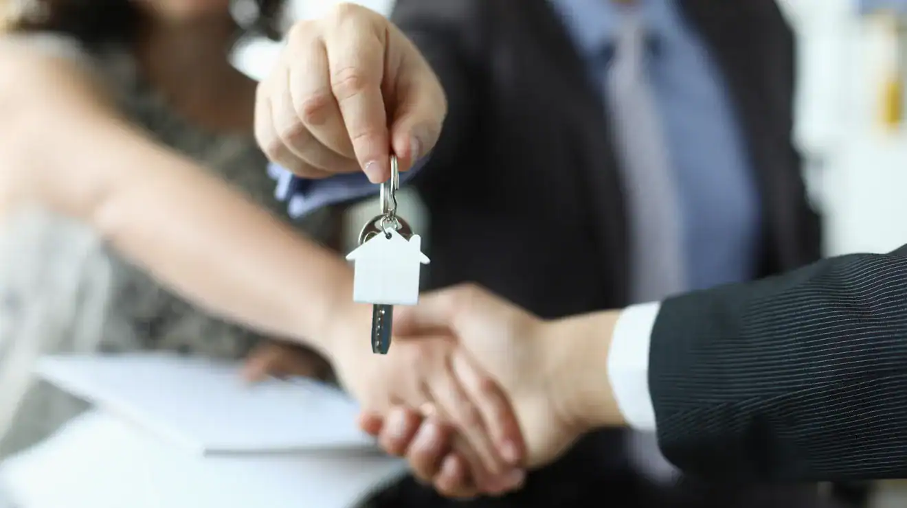 Agent handing house keys to a buyer