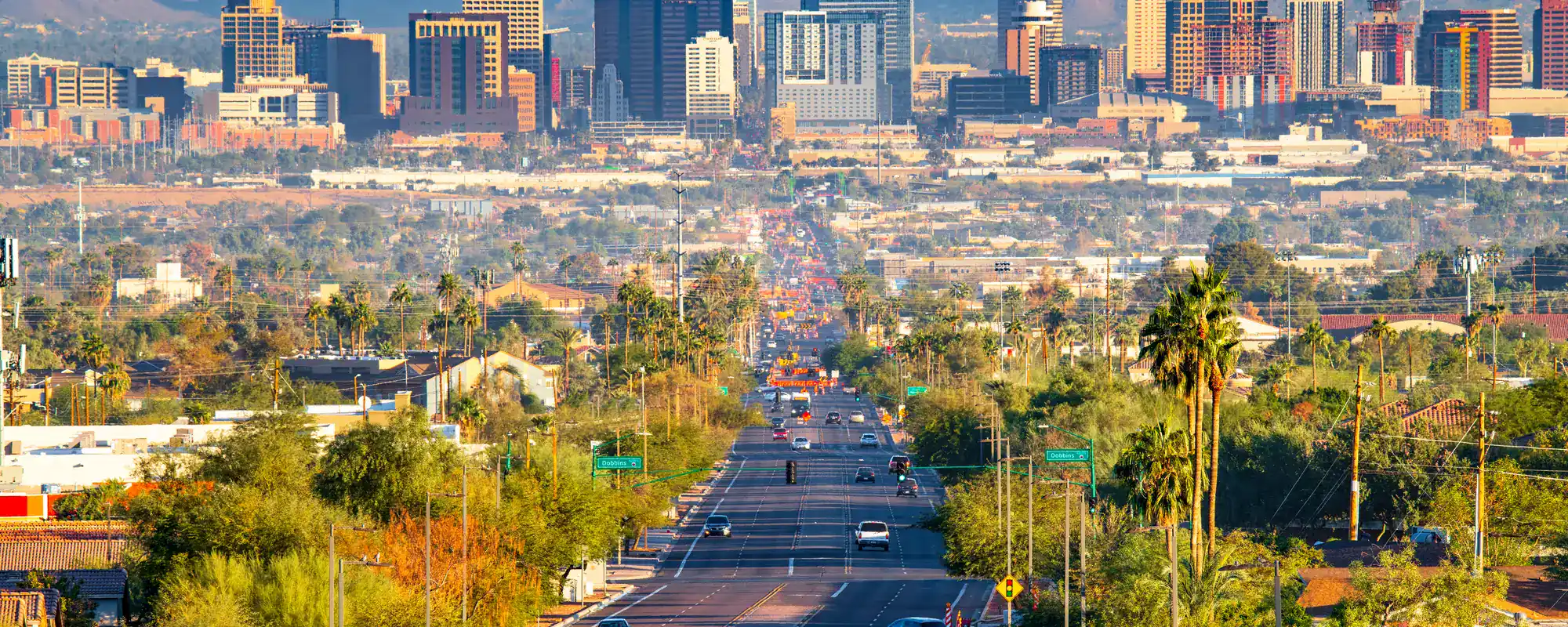 Downtown Phoenix skyline from a tree-lined street