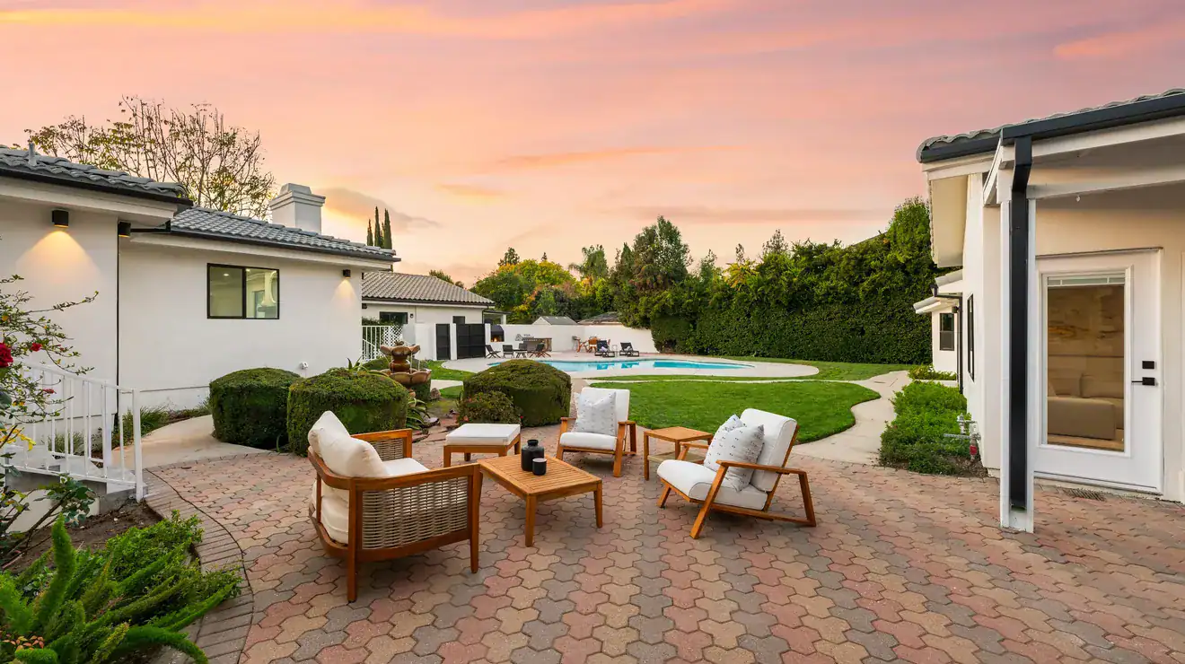 Backyard patio with modern furniture at sunset