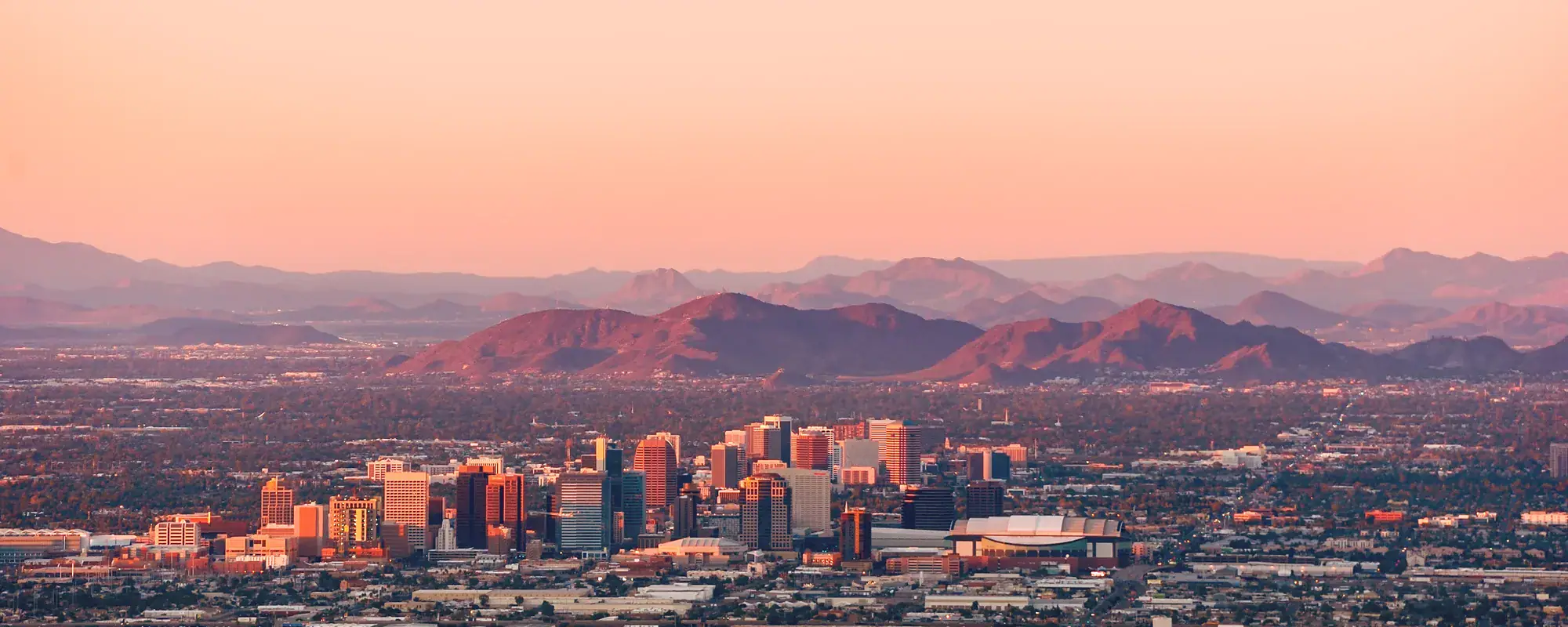 Phoenix, Arizona skyline at dusk with mountains beyond