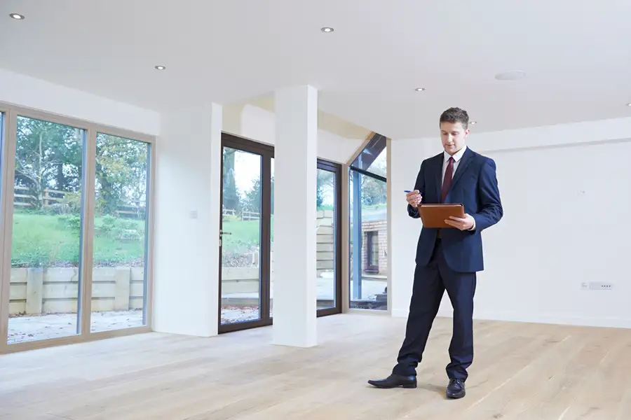 Estate Agent Looking Around Vacant Property For Valuation