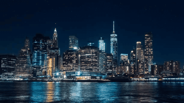 Lower Manhattan skyline lit up at night across the East River