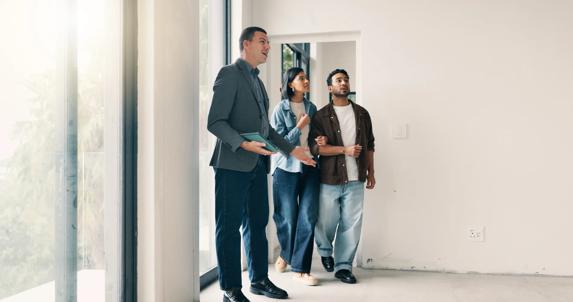 smiling african american real estate agent showing documents to smiling owners of new house in city