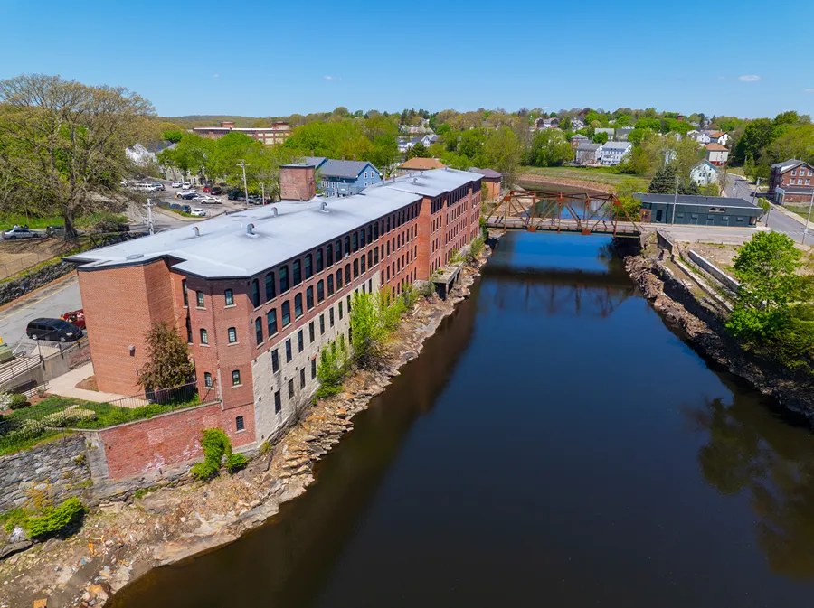 Sayles Street Bridge and Glenark Mills building on Blackstone River aerial view in downtown Woonsocket, Rhode Island RI, USA