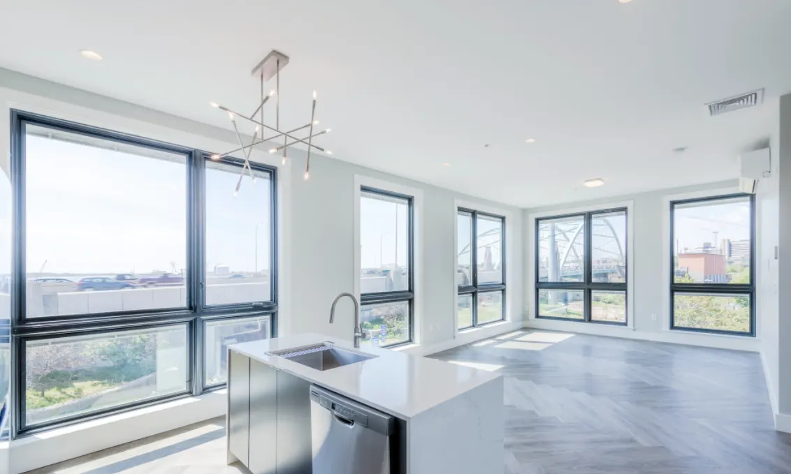 Bright corner living area at 580 South Water in Providence with floor-to-ceiling windows and a white kitchen island