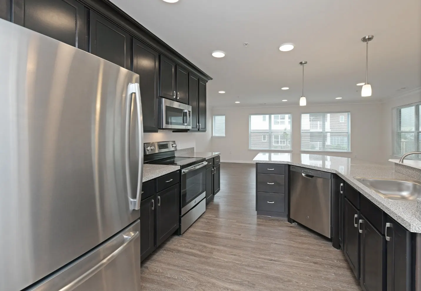 Open kitchen at Reynolds Farm in North Kingstown with dark cabinets, stainless steel appliances and granite counters