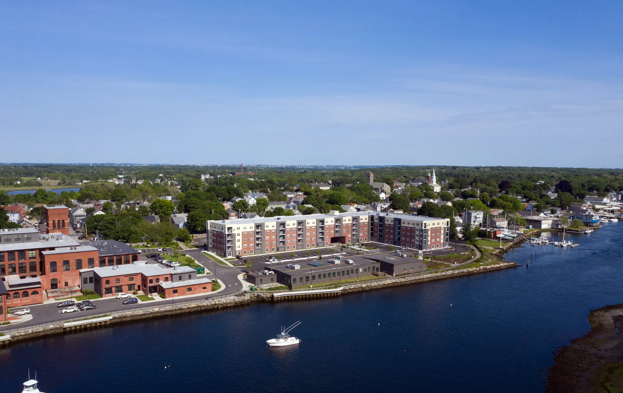 Aerial view of The Residences at 99 Water beside the river in Warren, with boats in the harbor
