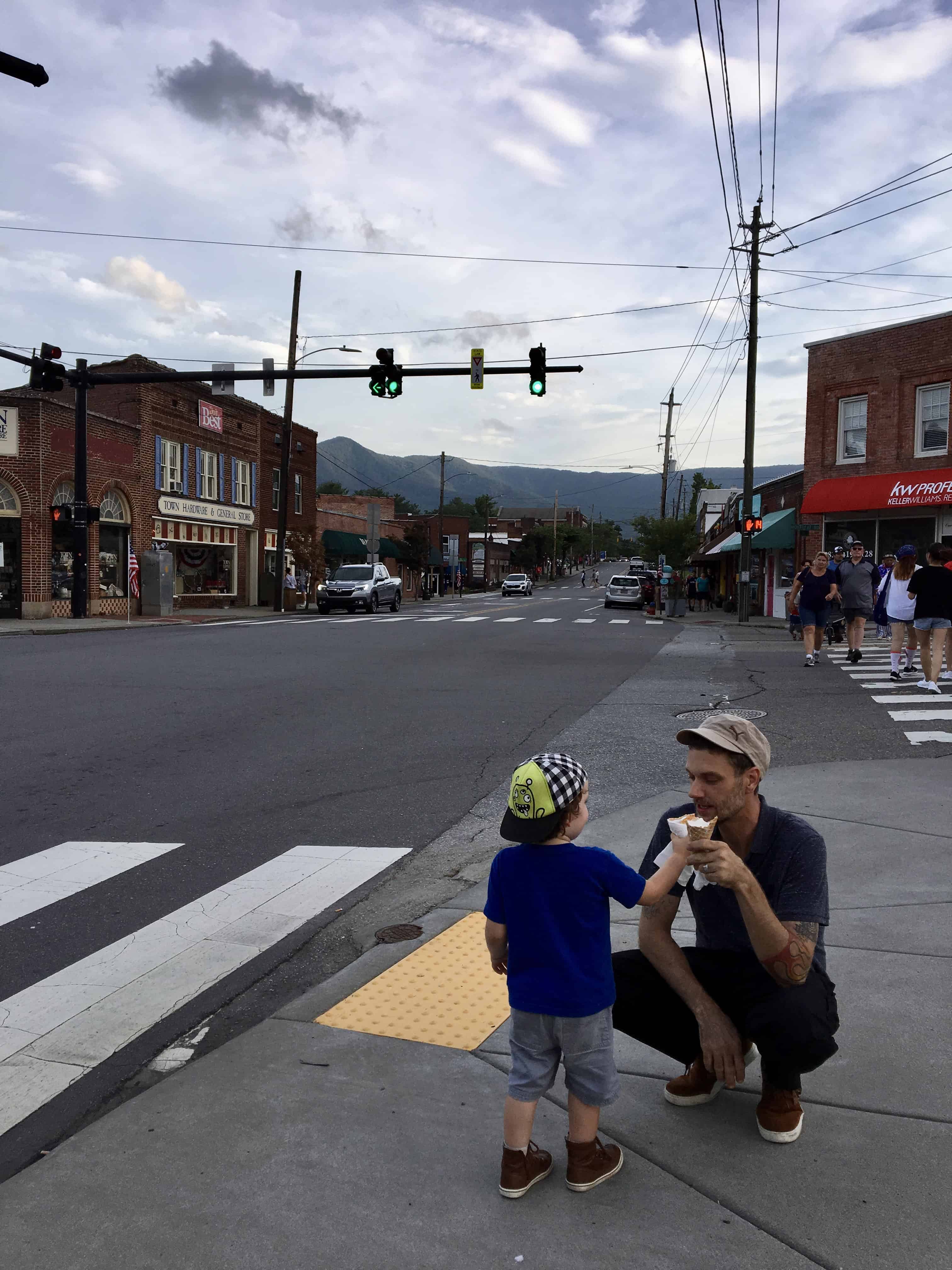 Man shares ice cream with child in Town Square in Black Mountain, North Carolina