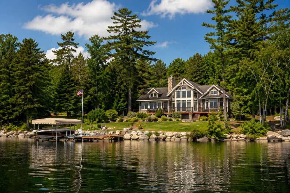 Vermont waterfront home with private dock overlooking a calm lake surrounded by trees
