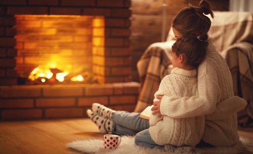 Warmly Dressed Sitting by Fireplace