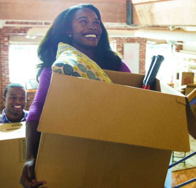 person carrying moving box while smiling