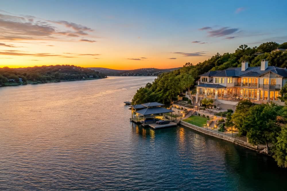 Luxury waterfront home overlooking a lake near Austin, Texas at sunset with private dock and Hill Country views