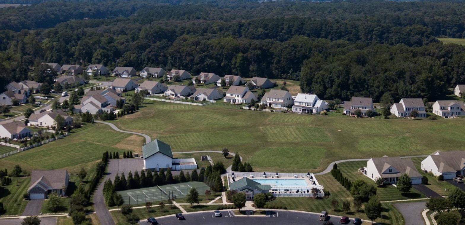 Aerial view of Harts Landing in Lewes, Delaware, with the clubhouse, pool and tennis court at the center