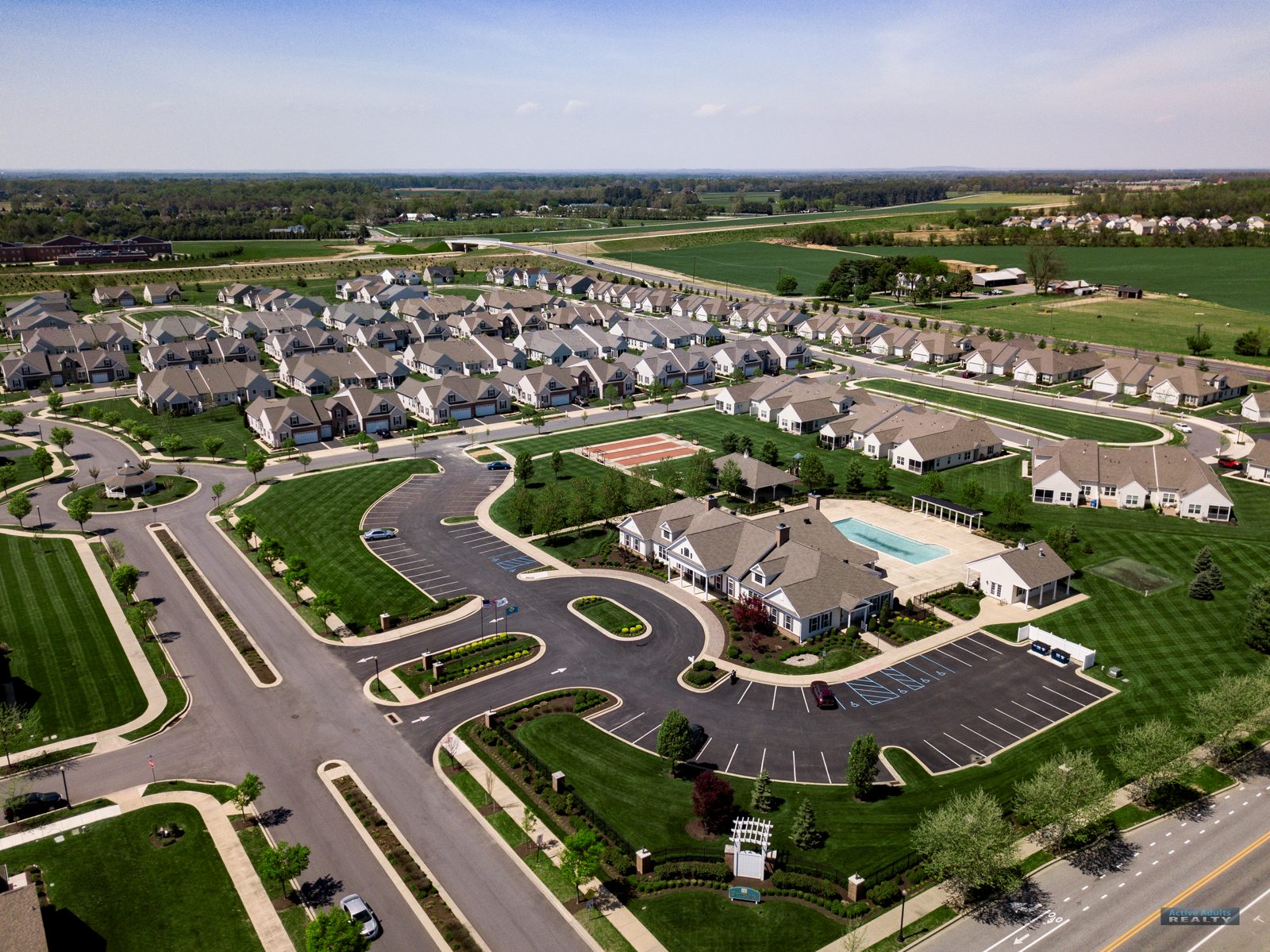 Wide drone view of Spring Arbor in Middletown with the clubhouse and pool at center