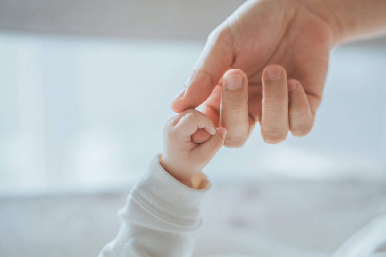 baby holding mothers hand