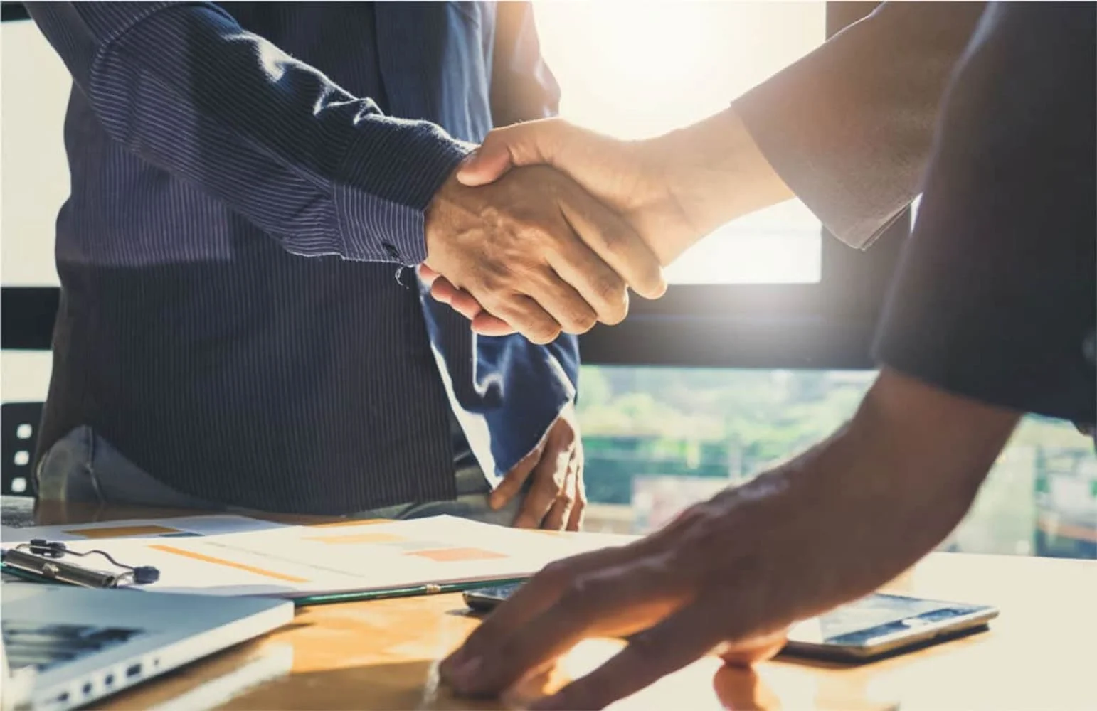 Two men are greeting each other by shaking hands