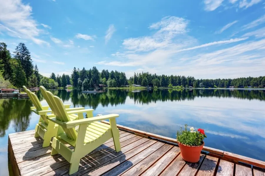 Happy man jumping off dock into lake the summer time